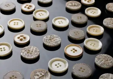 Bone buttons in natural and patterned finishes on black