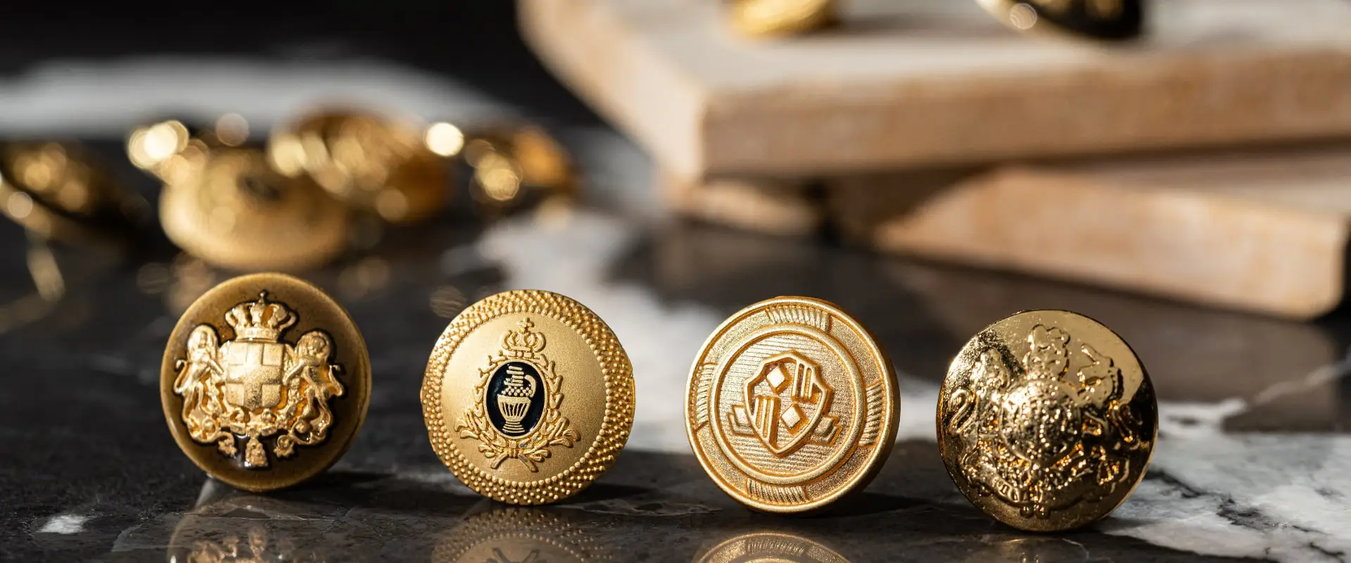 Four gold metal buttons with crests and monograms