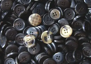 Dark horn buttons, some with engraved patterns