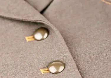 Gold metal buttons on a camel wool jacket