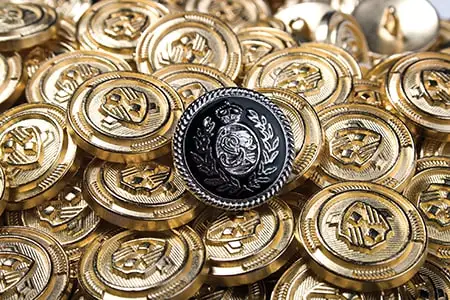 Gold crested metal buttons around a black and silver one
