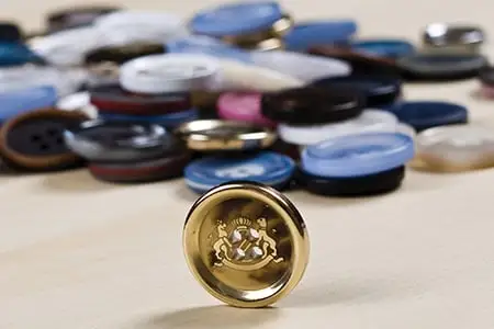 Polyester buttons in many colours behind a gold button