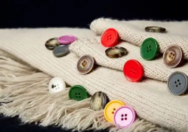Urea buttons in red, green and pink on knitwear