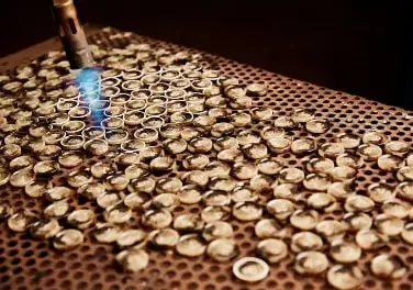 Urea buttons on a perforated tray under a laser beam